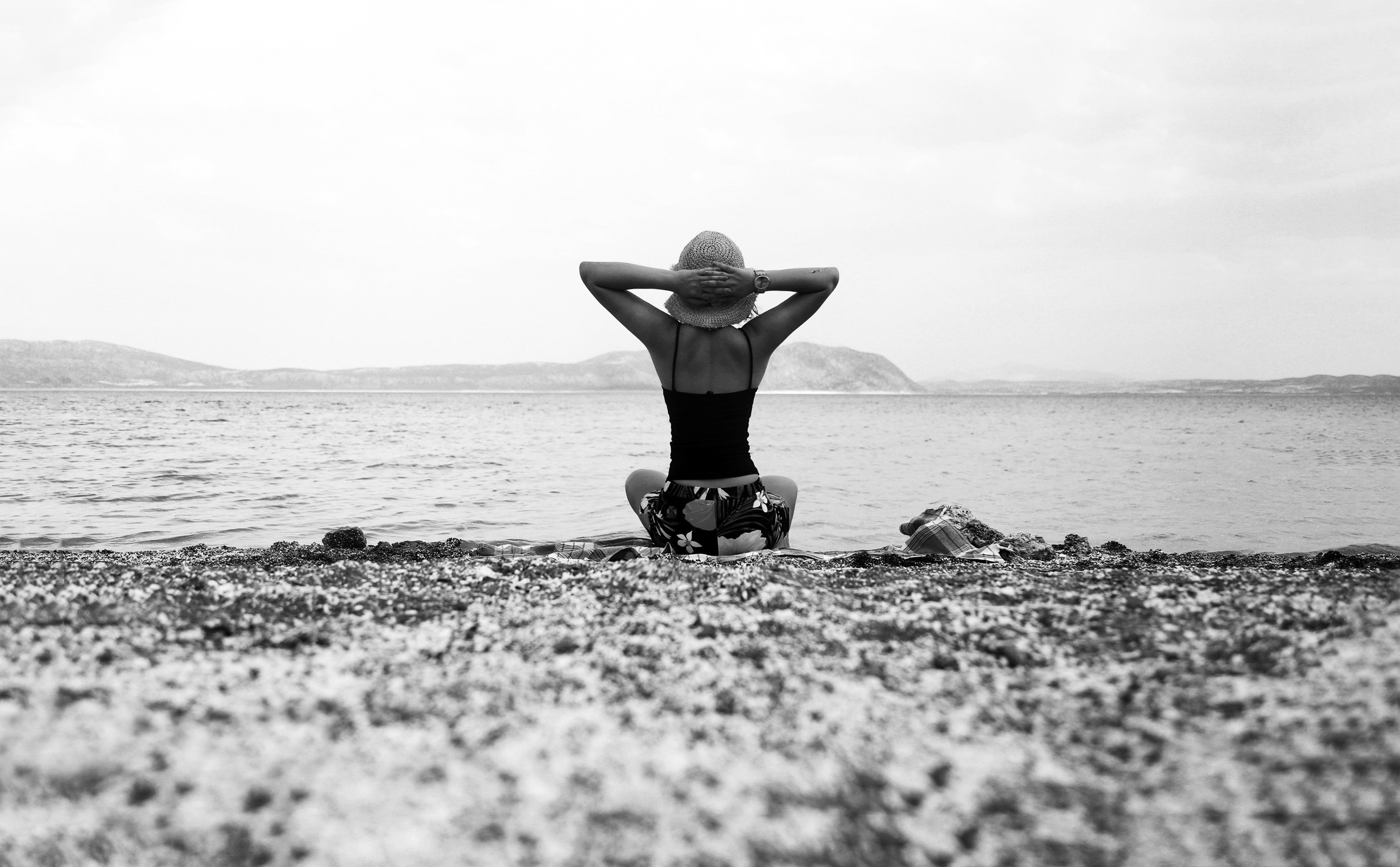 person-on-a-beach-with-their-hands-up-in-black-and-white.jpg